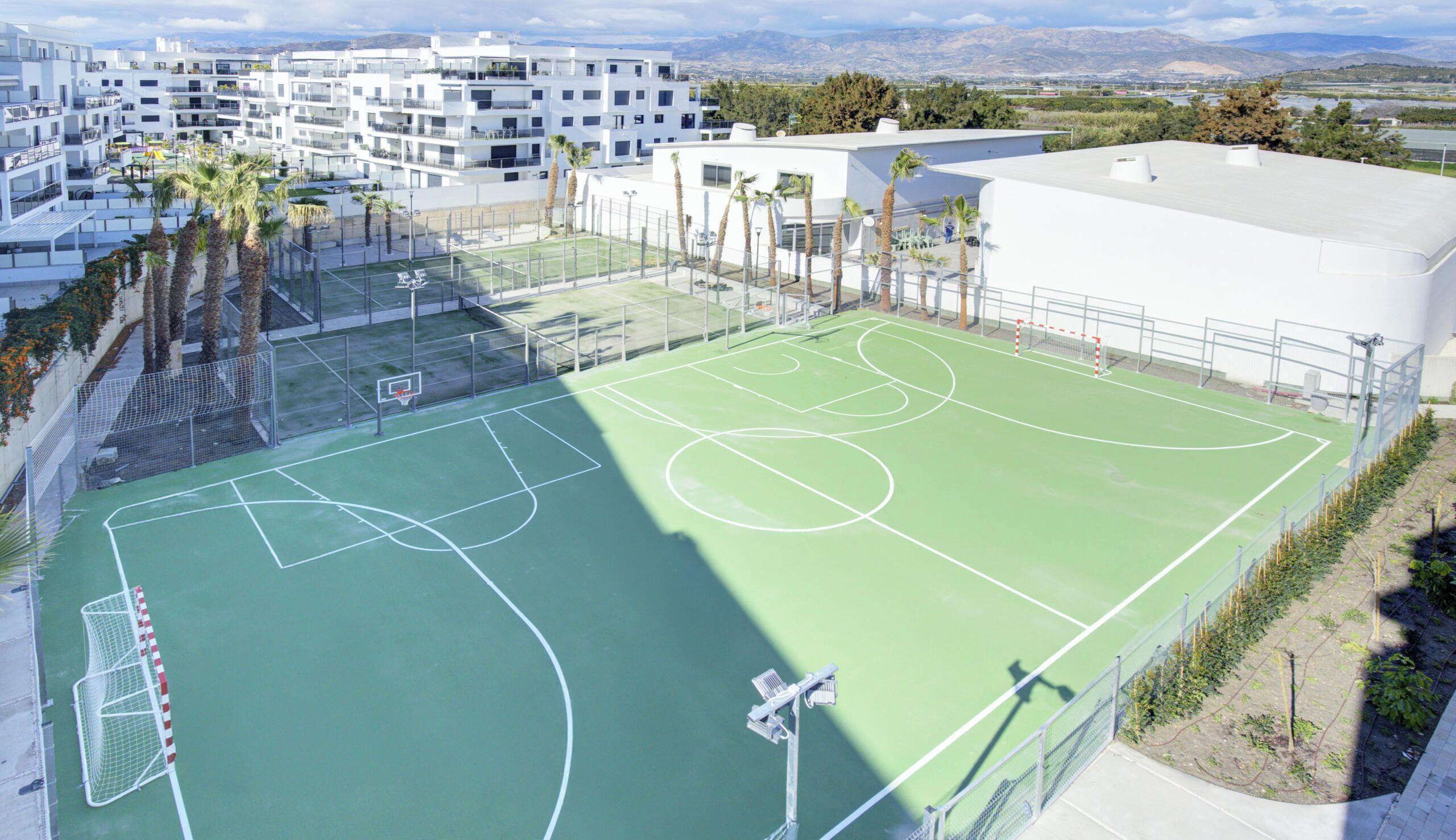 En flereetagers boligbygning med en basketballbane.
