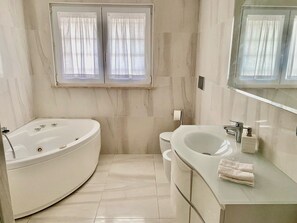 Chuveiro, banheira de hidromassagem, secador de cabelo, bidê