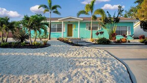 A two-story house with a light blue exterior, a front porch, and a driveway leading to the entrance. - 3 miles to AMI beach, 3 bed 2 bath, 4 miles to IMG (Bradenton)