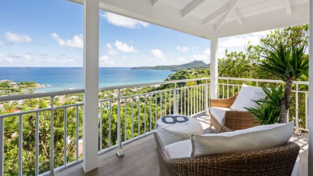 Balkon med fletningsmøbler, havudsigt og gelænder i hvid.