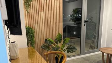 Un comedor moderno con una mesa de madera, sillas y un control remoto sobre la mesa.