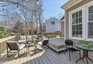 A wooden deck with outdoor furniture, including a sofa, chairs, and a table.