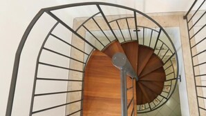 A spiral staircase with a wooden finish and metal railings. - Sweet World - Family Room with Terrace Near the Beach (Terrasini)