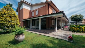 A two-story house with a covered patio, a brick exterior, and a well-maintained lawn. - Inn Rome B&B  (Rome)