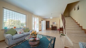 A spacious living room with a sofa, coffee table, and a staircase leading to another room. - Inn Rome B&B  (Rome)