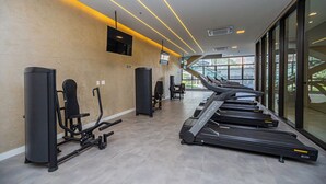 A gym with treadmills, weight machines, and a TV on the wall. - Flat c Piscina e Academia na Ch Cara Klabin (São Paulo)