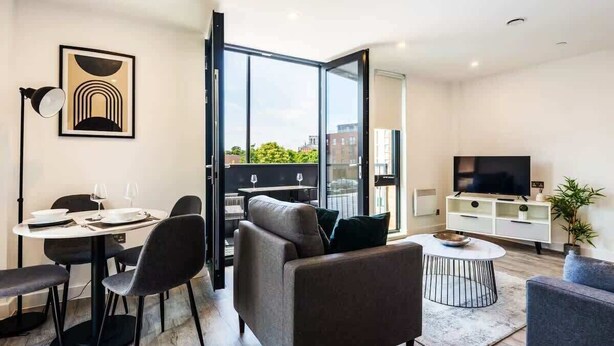 Ein modernes Wohnzimmer mit Essbereich, einer Couch, einem Couchtisch und einem Fernseher.