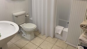 Une salle de bain équipée de toilettes, d’un lavabo, d’une douche et d’un porte-serviettes.