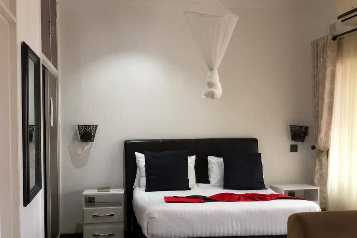 Een hotelkamer met een bed, nachtkastjes, een kledingkast en een klamboe.