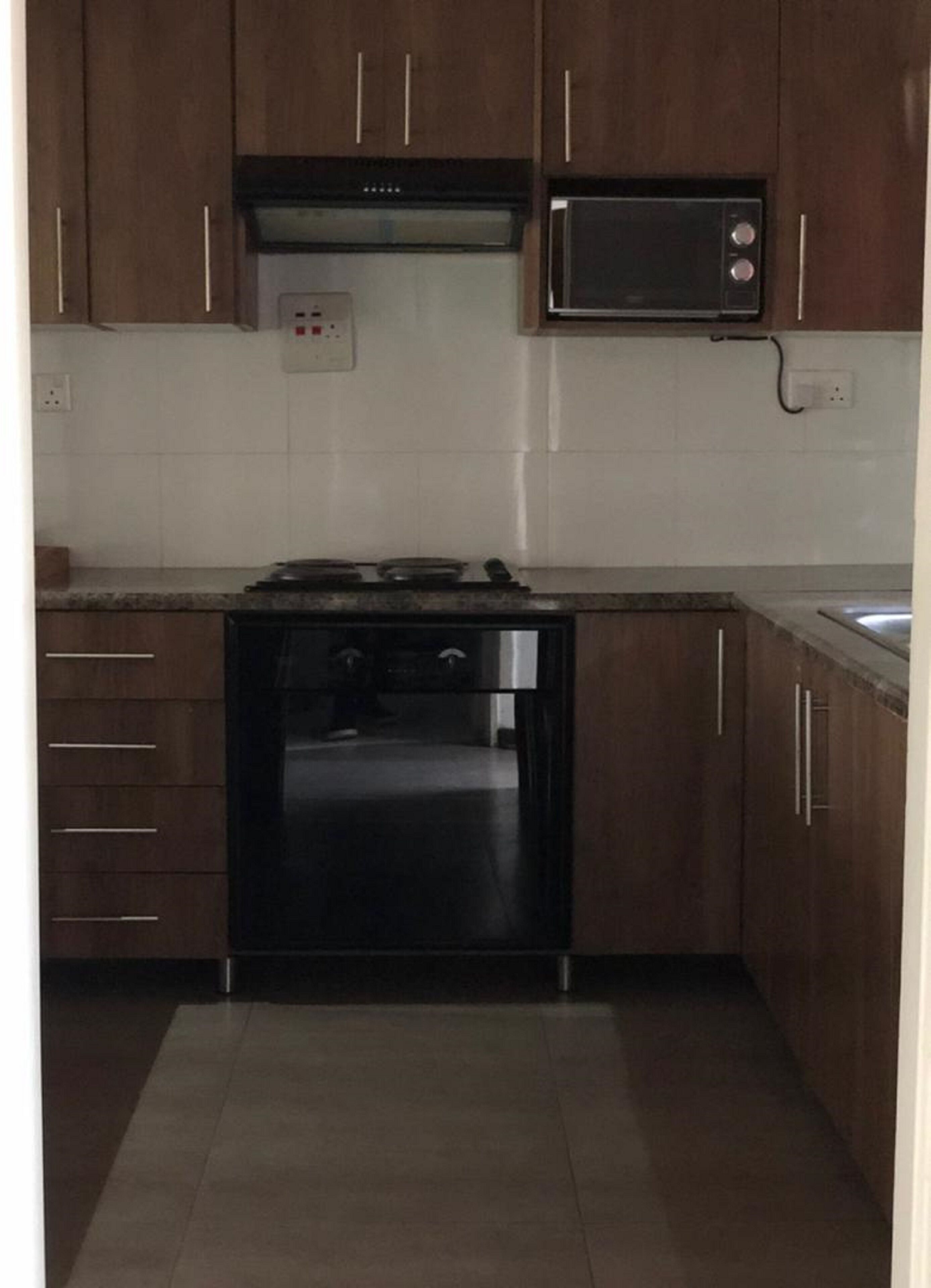 A compact kitchen with a stove, oven, microwave, and a small countertop.