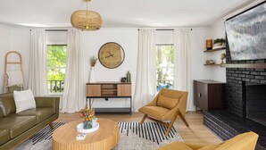 A modern living room with a fireplace, a round coffee table, a sofa, and a chair. - 4BR Pineville Retreat - Private Pool - Fire Pit - Near Carowinds & Charlotte (Pineville)