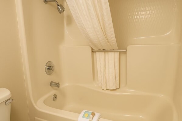 A bathroom with a bathtub, a toilet, and a shower curtain. - Hotel Inn Fairfield (Fairfield)