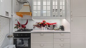 Een moderne keuken met witte kastjes, een zwarte oven en een rvs-afzuigkap.