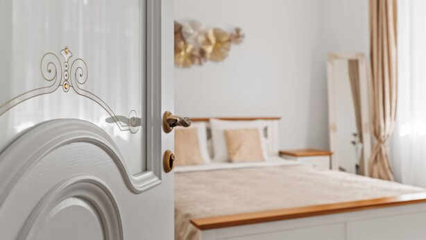 Een slaapkamer met een bed, nachtkastje en decoratieve wanddecoratie.