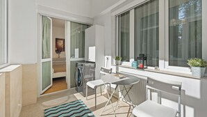 Een moderne keuken met een eethoek, een wasmachine en een groot raam dat zorgt voor daglicht.