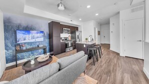 A modern apartment with a living room, kitchen, and dining area.