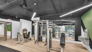 A gym with various exercise equipment, a mirror, and a water station.