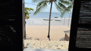 A beach view through a window with a palm tree, beach, and boats. - Igapeba Moreré (Cairu)