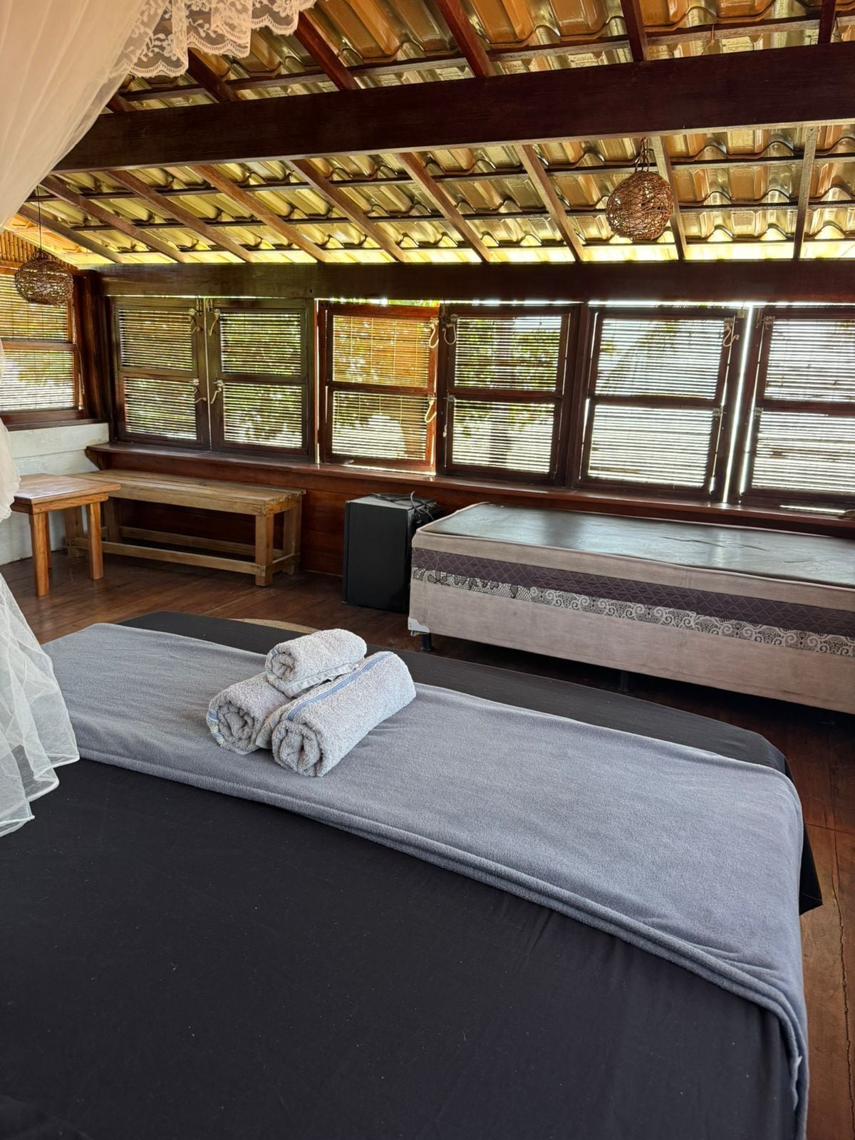 Una habitación con una cama, un banco y un altavoz.