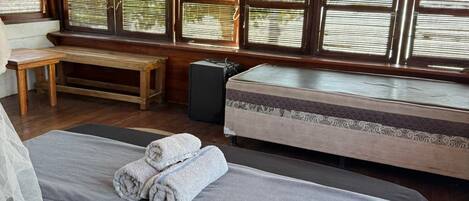 Una habitación con una cama, un banco y un altavoz.