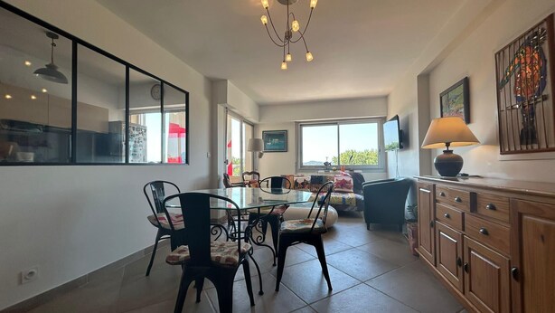 A spacious kitchen with a dining area, large windows, and a chandelier. - Apartment with view, quiet and comfort in Narbonne (Narbonne)