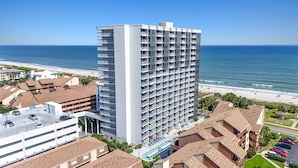 Un hotel di grattacielo con numerosi balconi affacciati su una spiaggia.