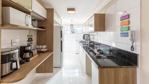 Eine moderne Küche mit schwarzem Arbeitsplatz, Edelstahlgeräten und Holzschränken.