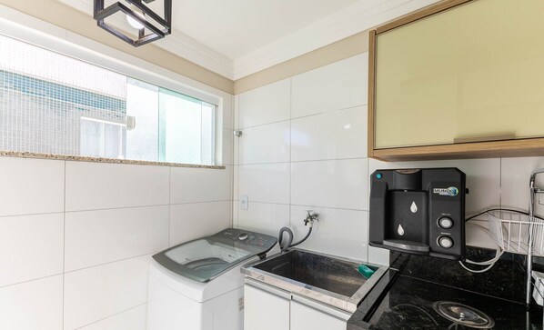 A compact kitchen with a washing machine, a coffee machine, and a sink. - Apart With sea View 200m From the Beach. Tsr0501 (Ilhéus)