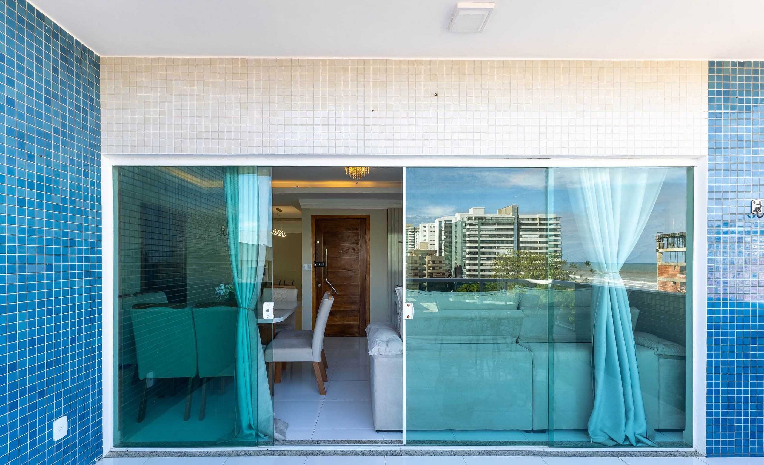 Ein modernes Hotelzimmer mit Balkon, einer Essecke und Blick auf die Stadt.