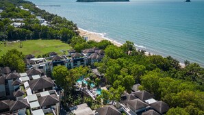 A resort with multiple buildings, a swimming pool, and a beach.