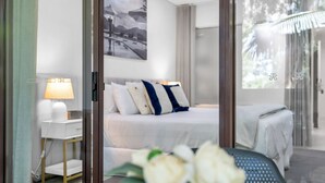 Un dormitorio moderno con una cama, una mesita de noche, una lámpara y un cuadro en la pared.