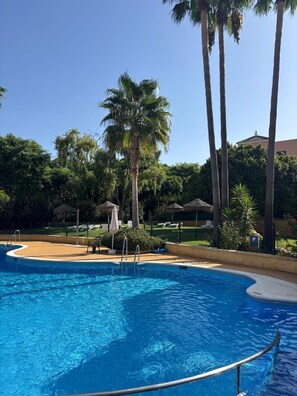 A swimming pool with palm trees and lounge chairs. - ISLANTUR IPANEMA (Isla Cristina)