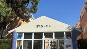 A building named IPANEMA with a covered entrance, AT sign, and a blue-tiled pillar. - ISLANTUR IPANEMA (Isla Cristina)