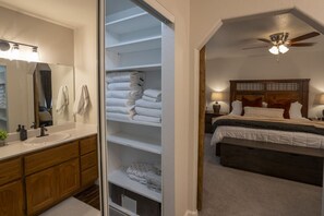 Ein Schlafzimmer mit Bett, Nachttisch, Lampe und Deckenventilator.