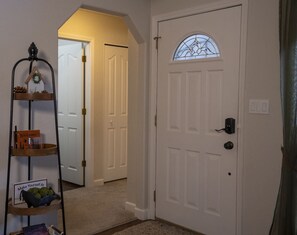 A white door with a glass window, a welcome sign, and a sign that says 'Make Yourself At Home.'
