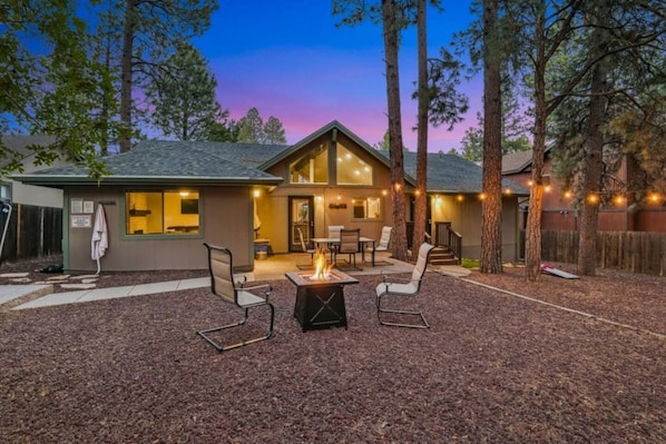 A two-story building with a patio area featuring a fire pit and outdoor seating.