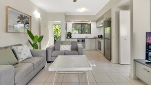 Une cuisine moderne avec un coin repas, un ventilateur de plafond et une grande fenêtre.