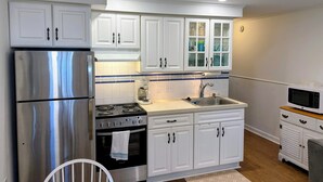 A modern kitchen with white cabinets, stainless steel appliances, and a tiled backsplash. - Beach block condo minutes to the boardwalk in Ocean City - Perfect for a getaway (Ocean City)