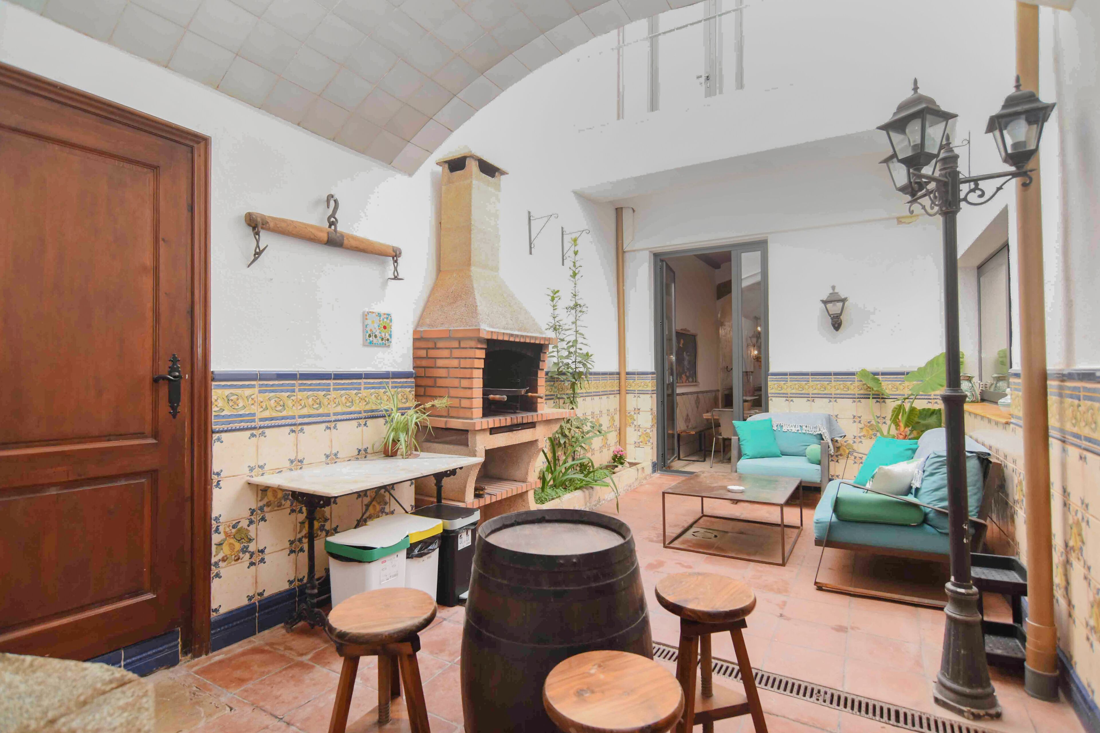 Un patio acogedor con horno de ladrillo, asientos y vistas al interior.
