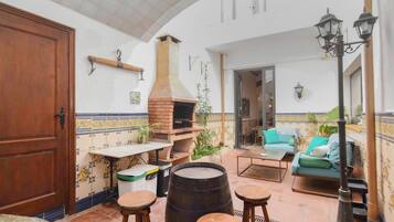 Un patio acogedor con horno de ladrillo, asientos y vistas al interior.