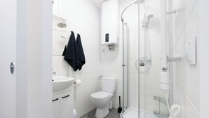 A modern bathroom with a toilet, sink, and shower. - A2 Vistula Apartments Kraków (Kraków)
