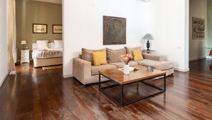 A modern living room with a sofa, coffee table, and artwork. - Apartamento de Tres Habitaciones con Terraza 11B (Barcelona)