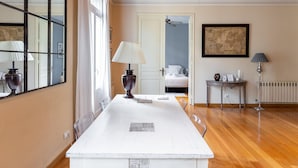 A hotel room with a large mirror, a white table, a bed, and a radiator. - Apartamento de dos Habitaciones (Barcelona)