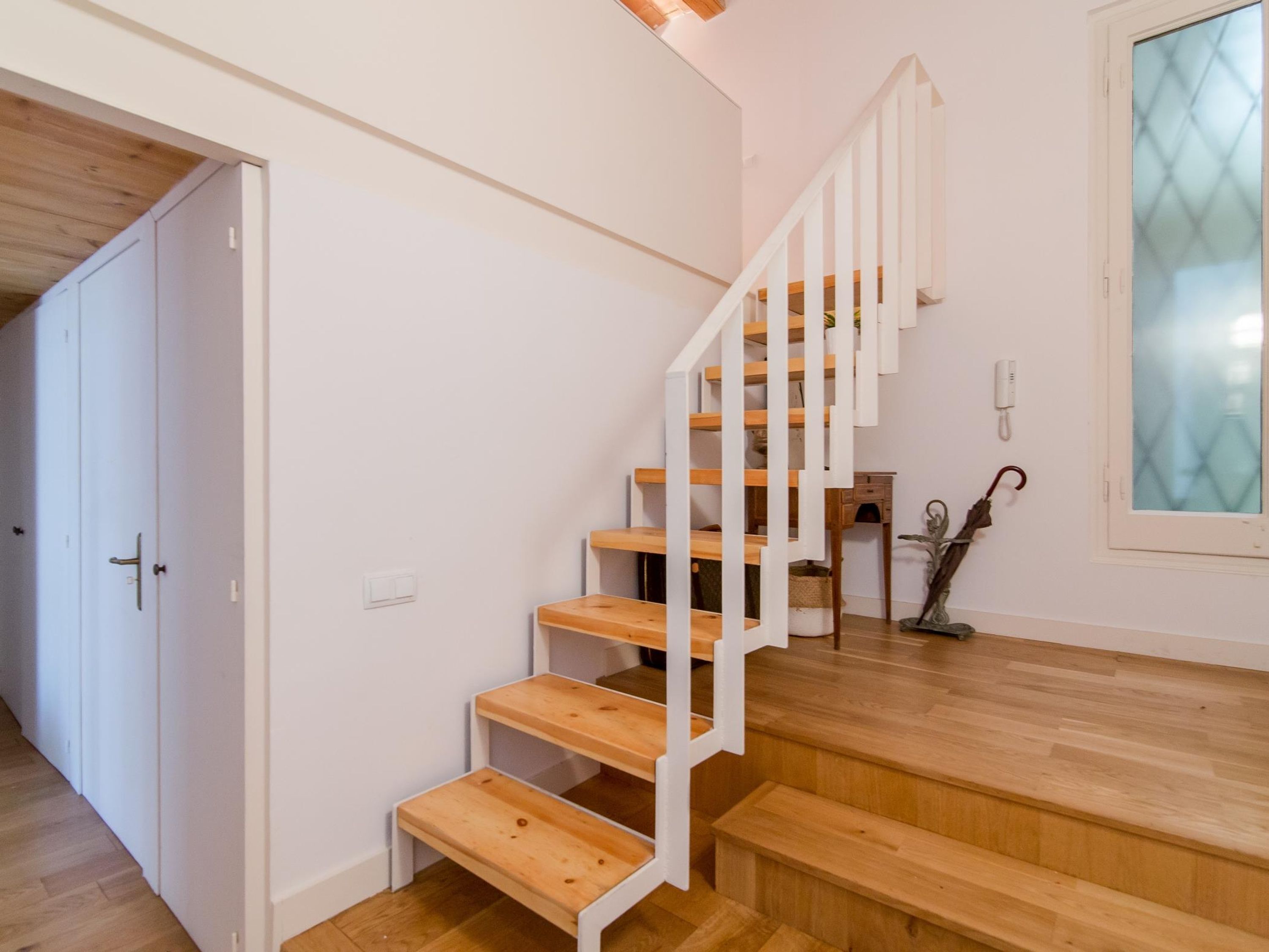 Una escalera con barandillas blancas y peldaños de madera.