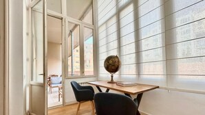 A study room with a wooden desk, two black chairs, a globe, and a book. - Designer s Three Bedroom Apartment With Terrace (Barcelona)