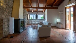 A spacious living area with a fireplace, a sofa, and a dining table. - Rossy house Sorrento (Sorrento)