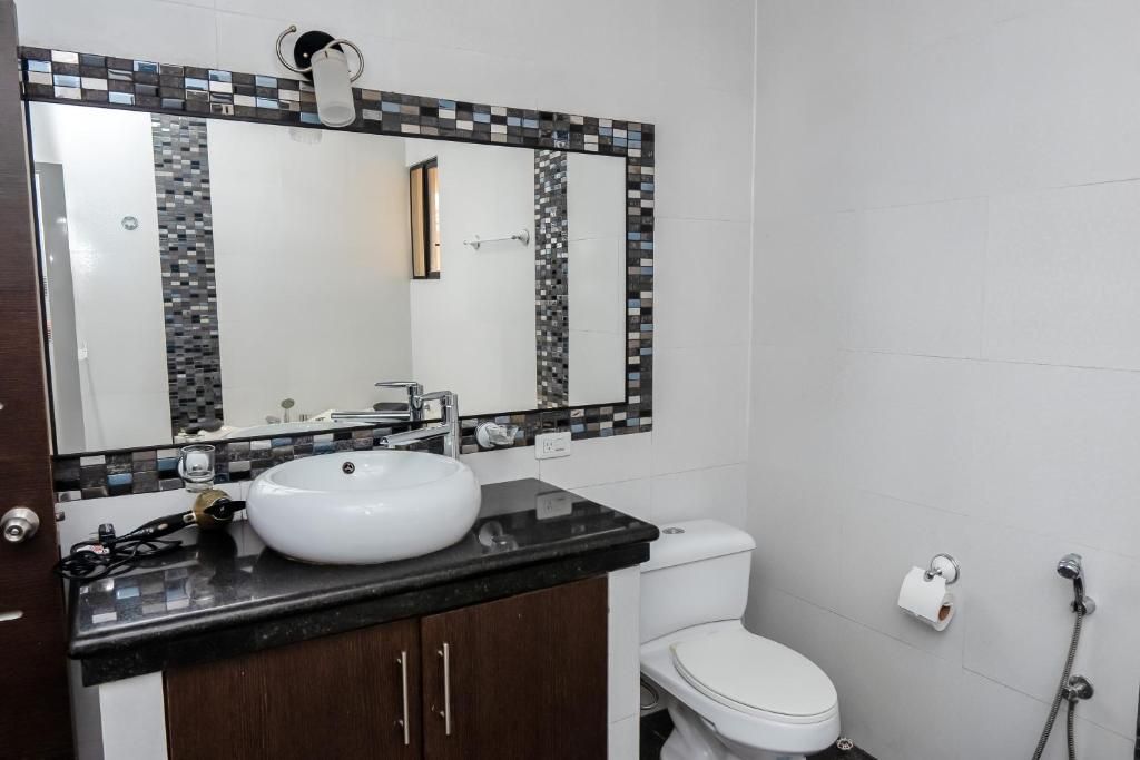 Un bagno con lavandino bianco, un water e una doccia.