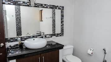 Un bagno con lavandino bianco, un water e una doccia.