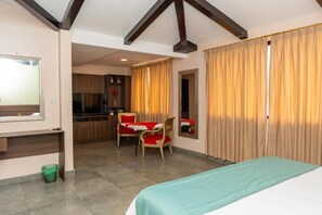 A hotel room with a bed, a desk, a chair, and a kitchenette. - CRESPOTEL (Quevedo)
