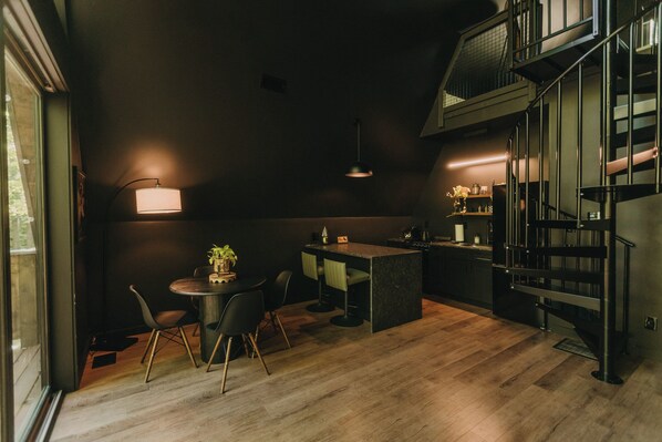 Una cocina moderna con comedor, una escalera y vistas al exterior.